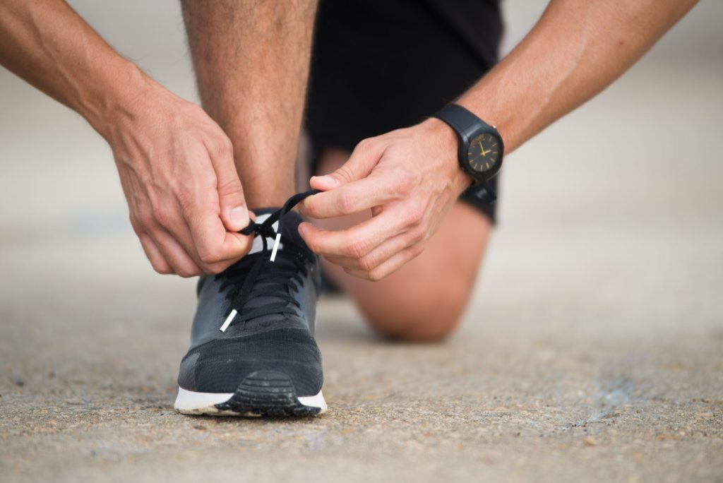 Close up sportsman tying sneakers