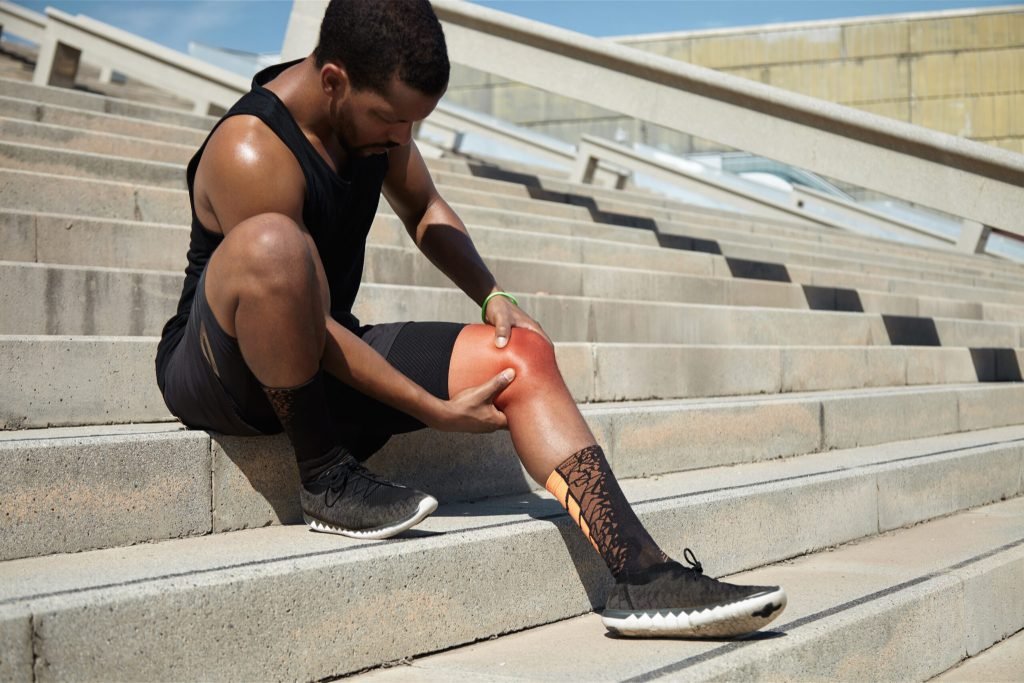 Closeup young man with knee injury