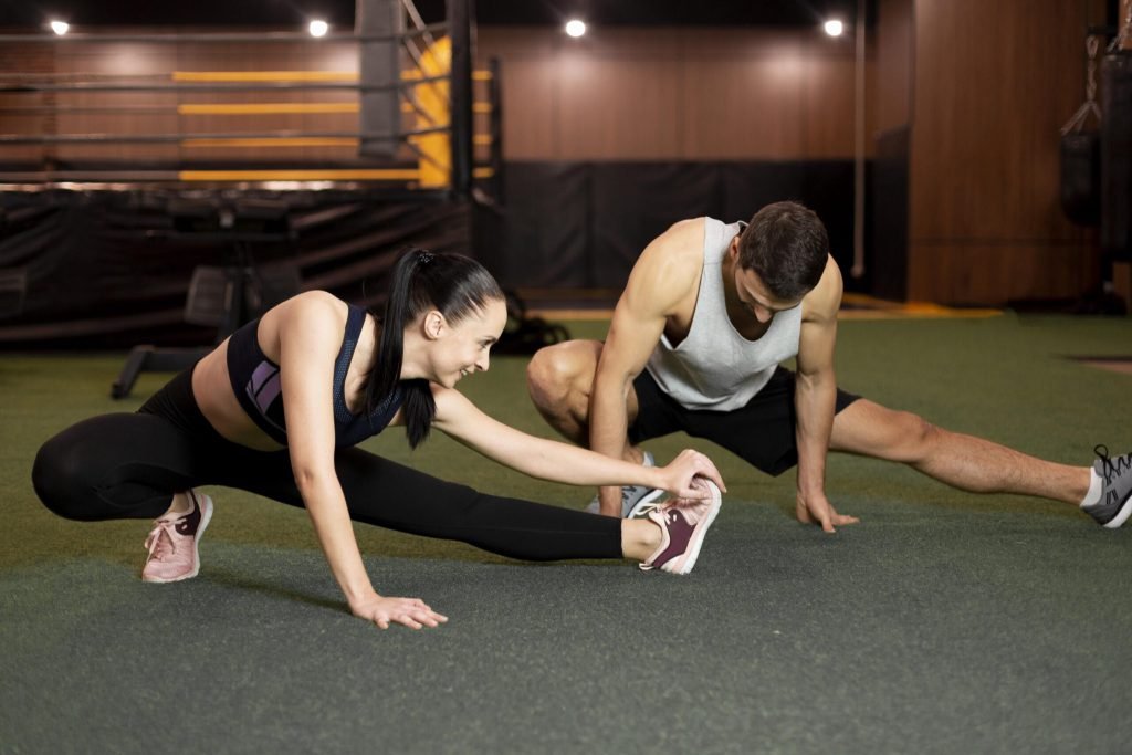 Full shot man woman stretching