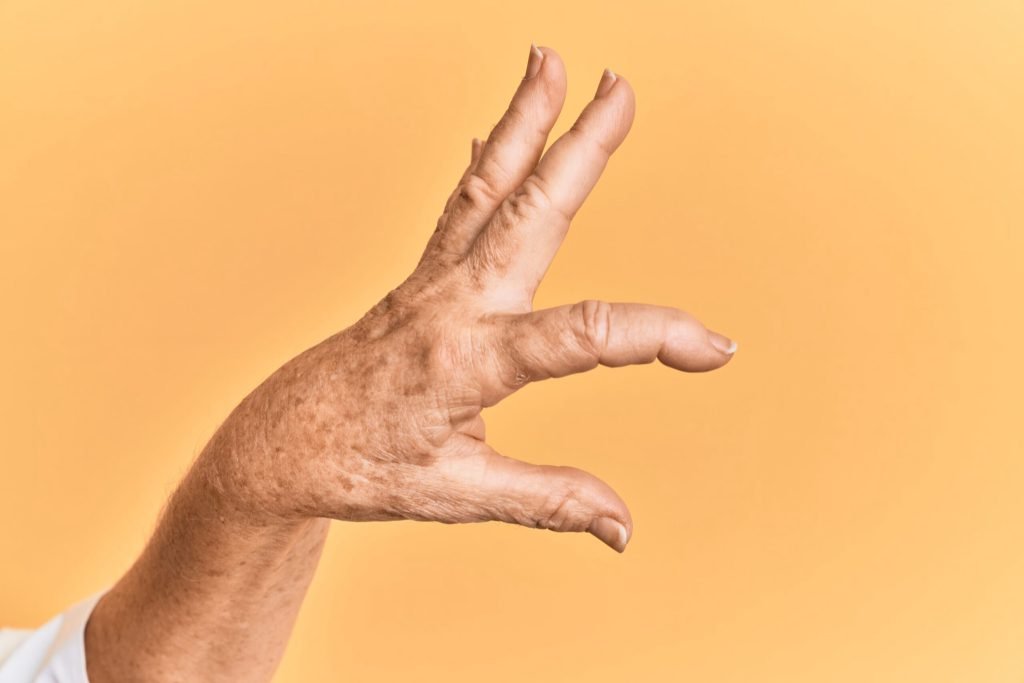 Senior caucasian hand yellow isolated background picking taking invisible thing holding object with fingers showing space