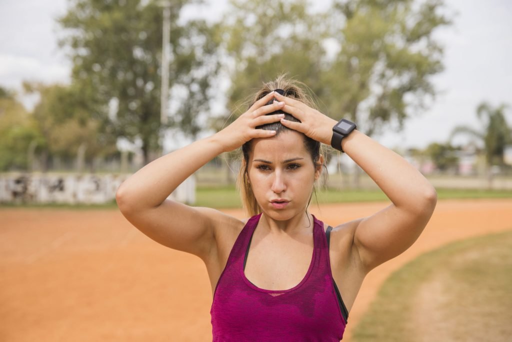 Sporty woman stretching stadium track