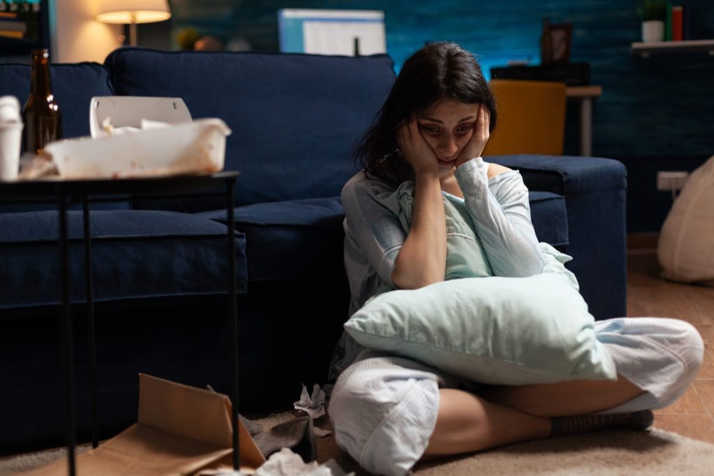 Lonely traumatised frustrated ill woman holding head hands feeling vulnerable
