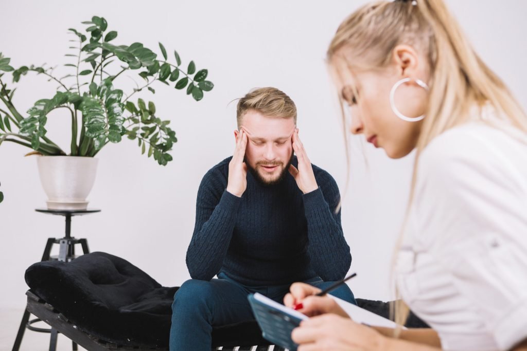Young female psychologist is writing down her thoughts about depressed patient