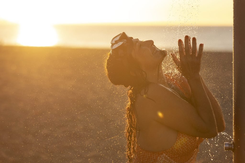 Portrait woman taking shower beach