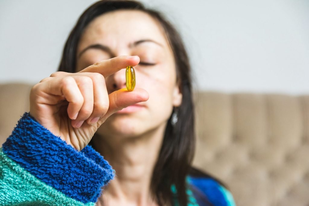 Woman holding yellow pill front her face