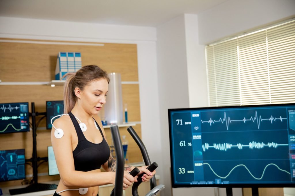 Female athlete who makes physical effort stepper has electrodes attached it results are seen screen sports laboratory