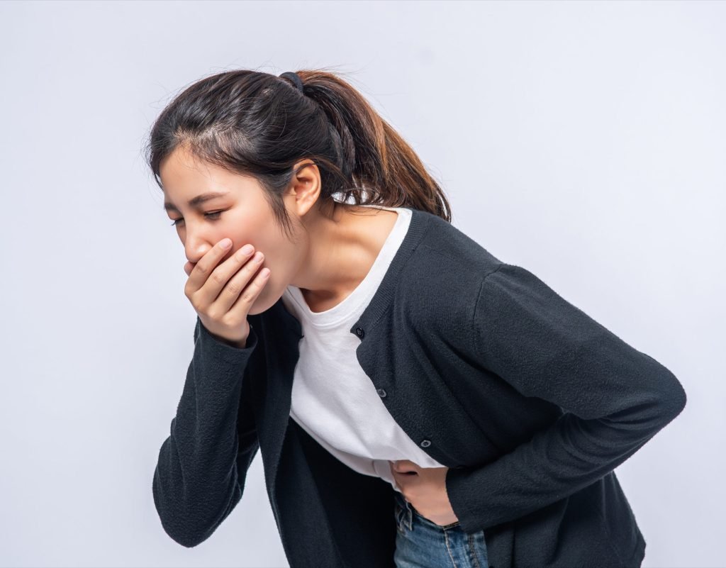 Woman with stomachache puts her hands her stomach covers her mouth
