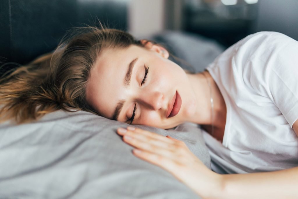 Beautiful young brunette woman sleeping white bed