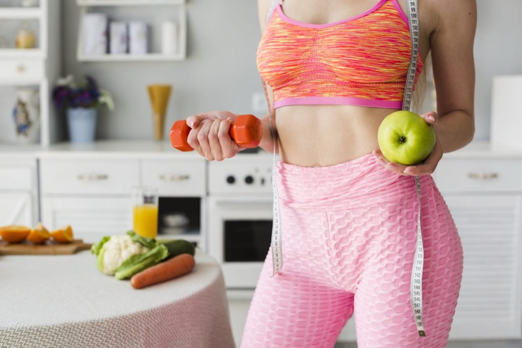 Diet concept with sporty woman kitchen