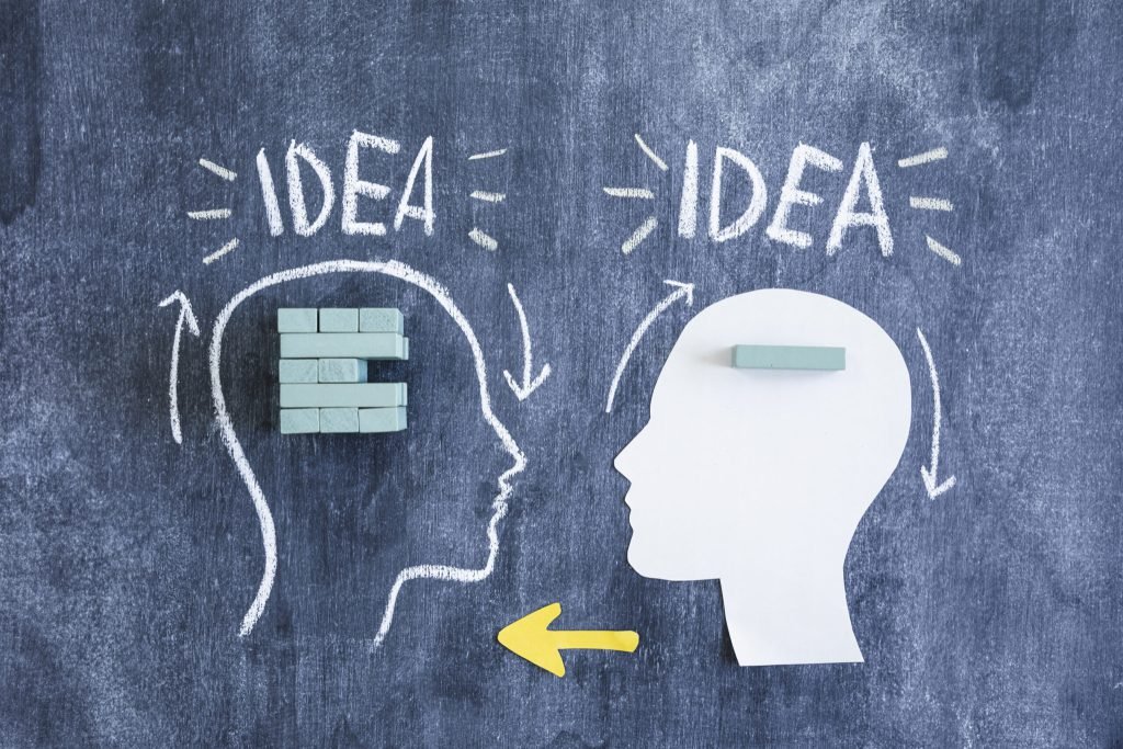 Drawn paper cutout with arrows exchanging thoughts blackboard with blocks idea text
