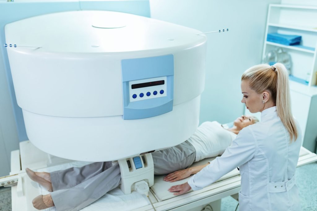 High angle view female radiologist mature patient knee mri scan procedure hospital