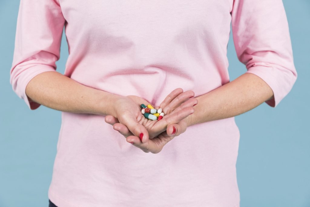 Mid section woman holding variety capsule s hand
