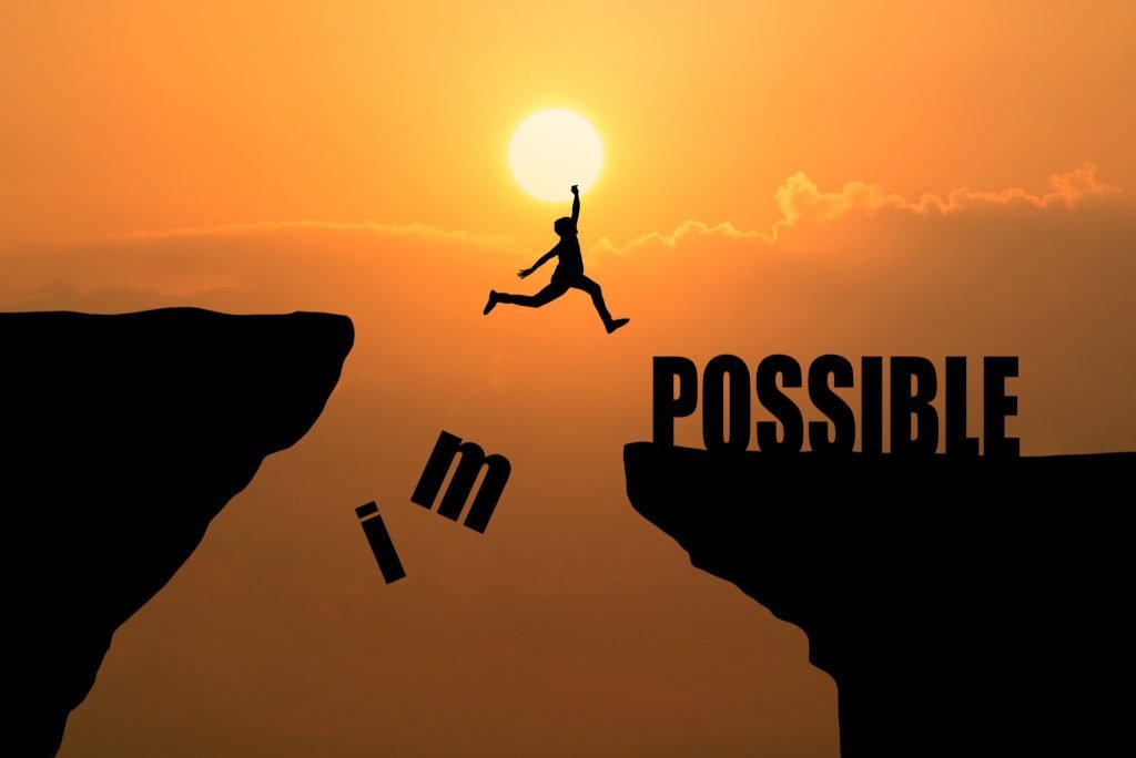 Man jumping impossible possible cliff sunset background business concept idea