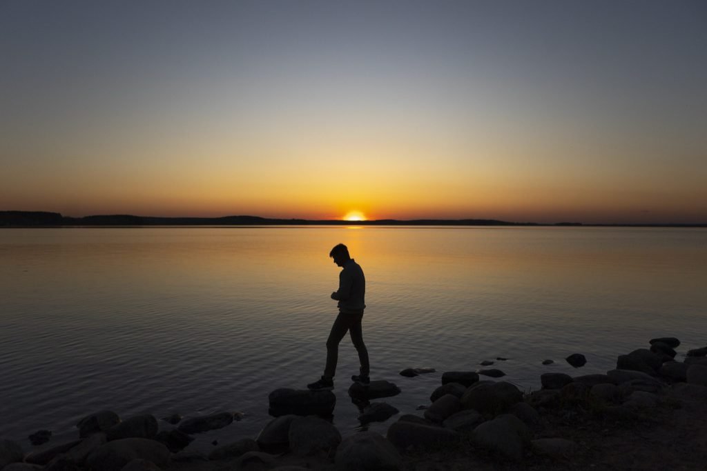 Sad contemplative person near lake