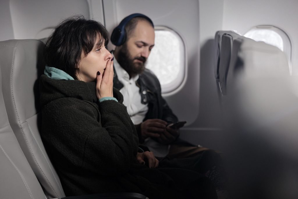 Woman feeling tense scared about airplane takeoff being frightened about flying abroad travelling with international airwa...