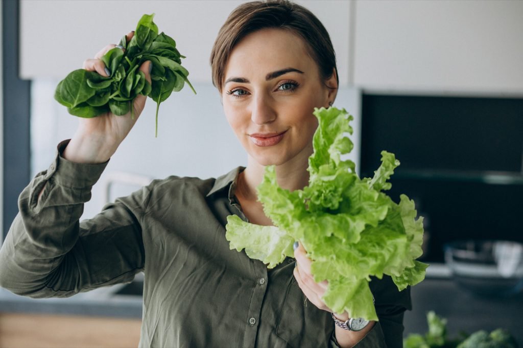 Woman with green vegetables kitchen