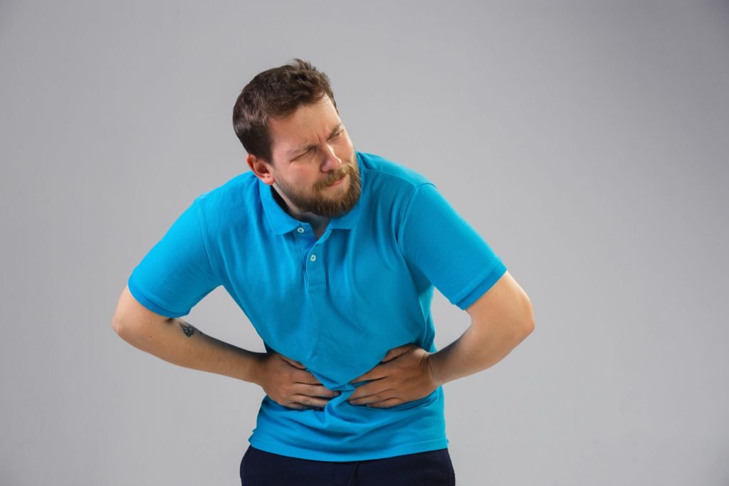 Young caucasian man suffers from abdominal pain