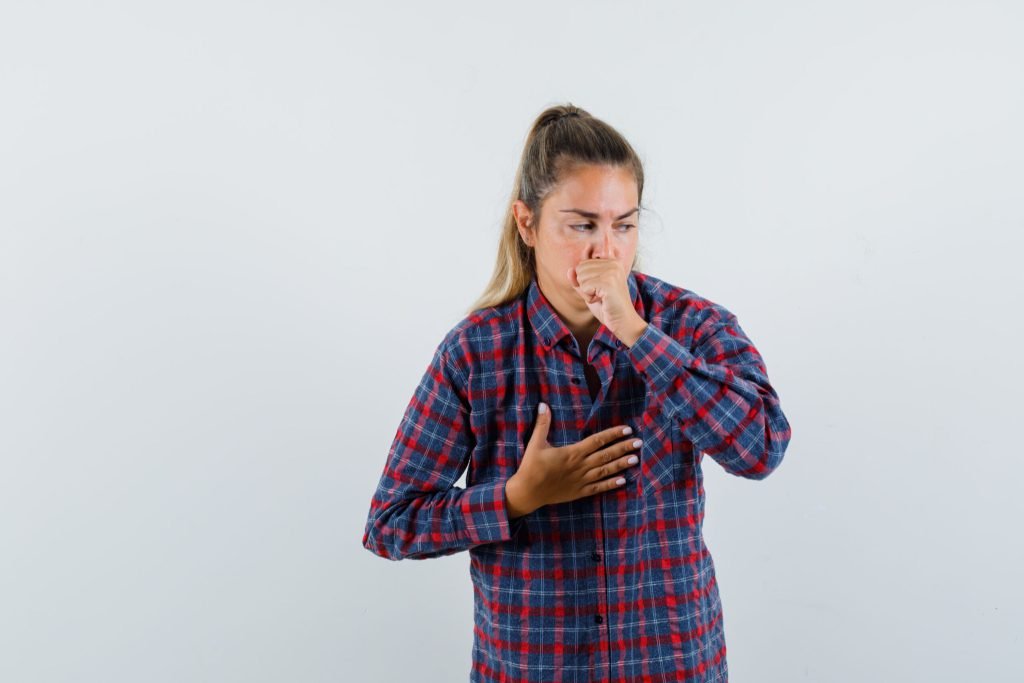 Young lady checked shirt suffering from cough looking sick front view