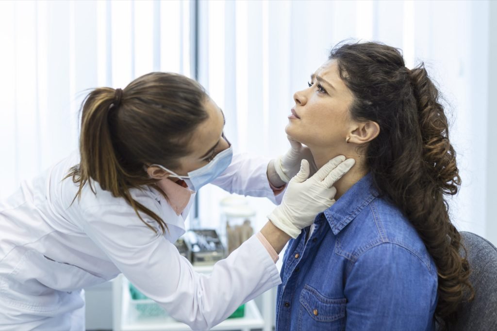 Endocrinologist examining throat young woman clinic women with thyroid gland test endocrinology hormones treatment inflamm...