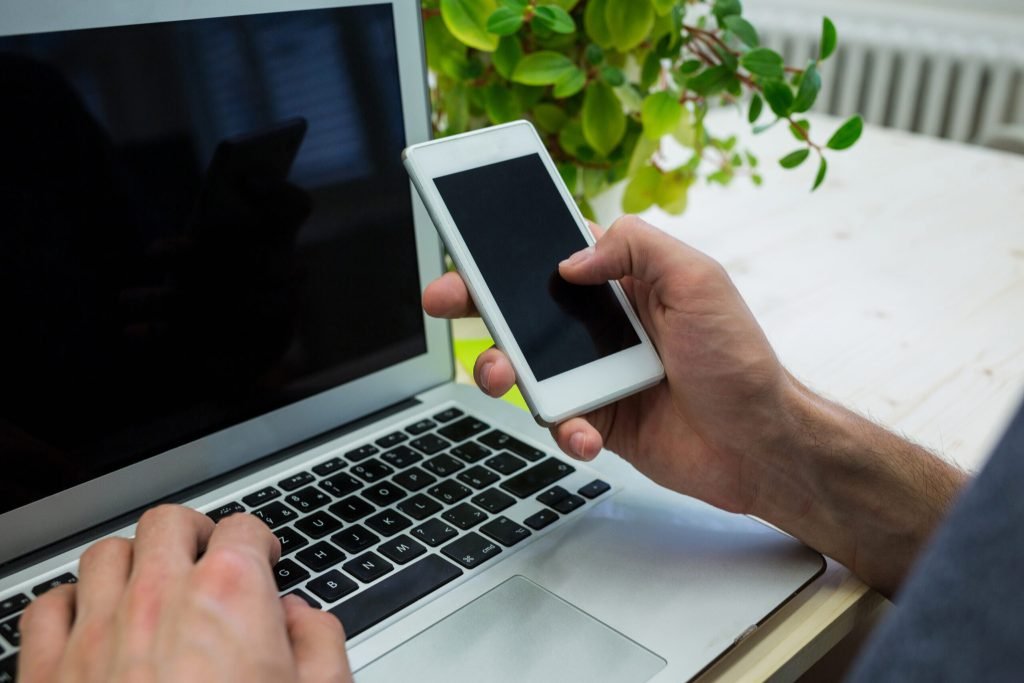 Hands male executive using mobile phone laptop