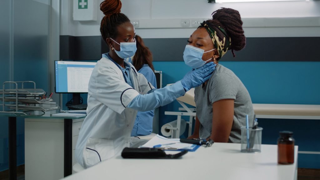 Medical specialist consulting patient with disease while wearing face mask annual checkup visit young person receiving con...