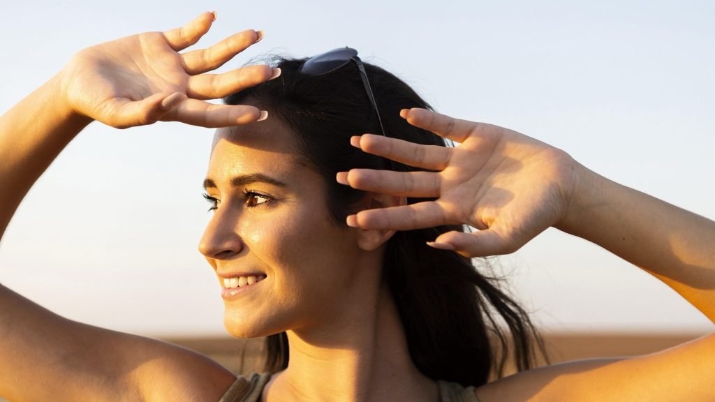 Smiley woman outdoors sun covering her face