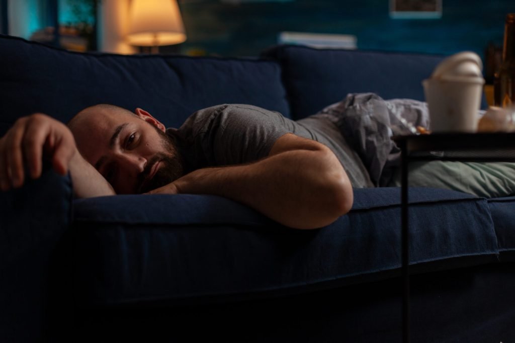 Depressed anxious adult with mental illness laying couch feeling pensive frustrated sad desperate man with suicidal though...
