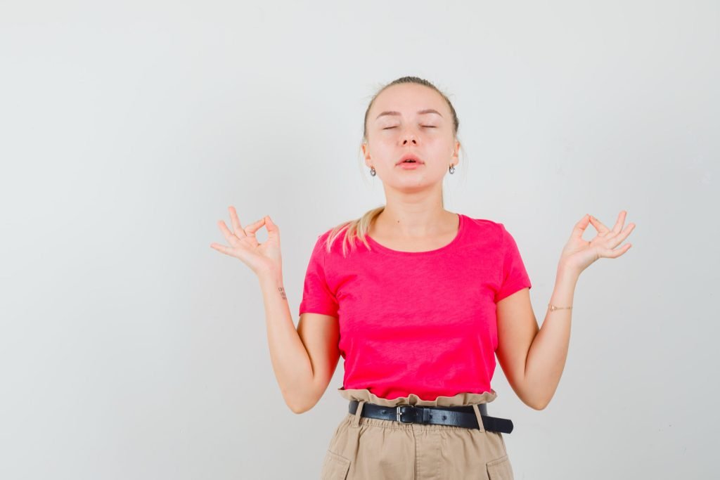 Young woman t shirt pants doing meditation with closed eyes looking relaxed