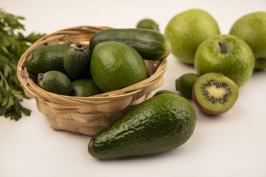 Top view avocados with cucumber bucket with green apples kiwi isolated white surface