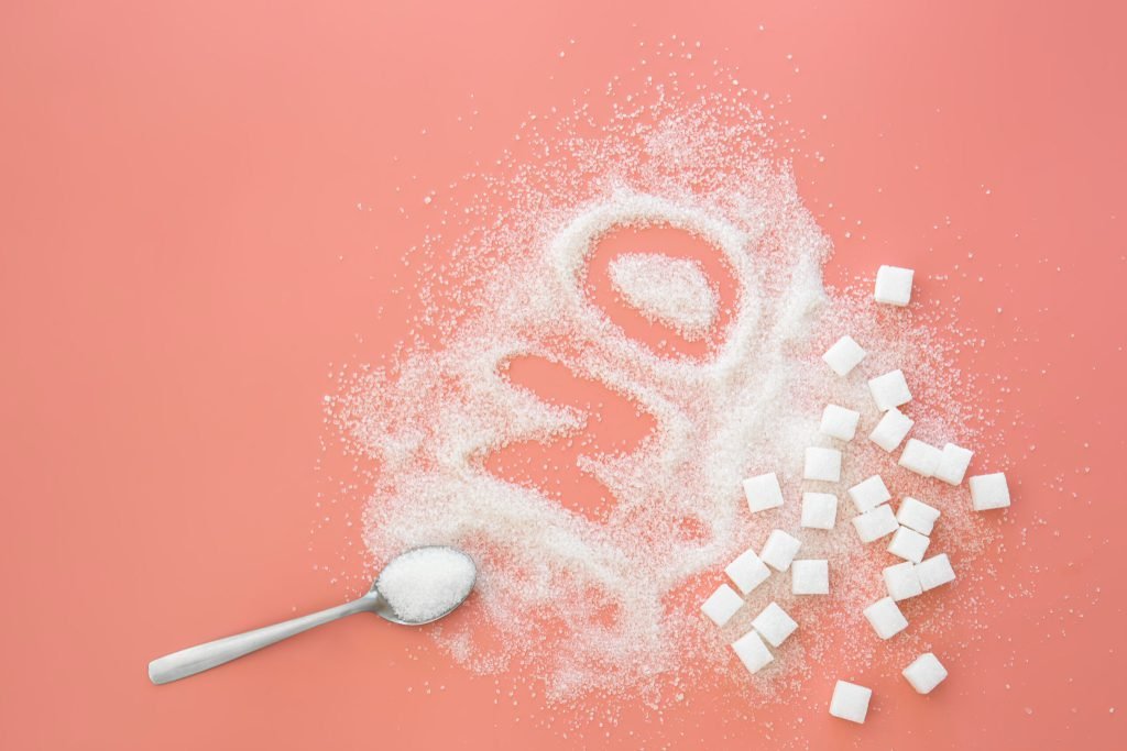 Word no made sugar spoon pink background flat lay