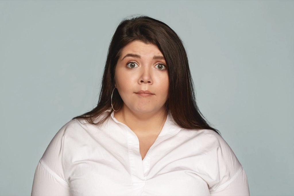 Astonishment surprise shock amazement attractive emotional young brunette female employee with excess weight having scared...