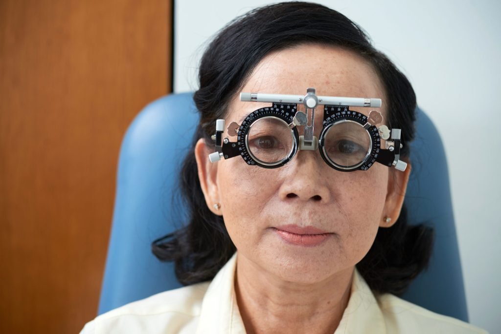 Mature asian lady wearing trial lens frame eyesight examination