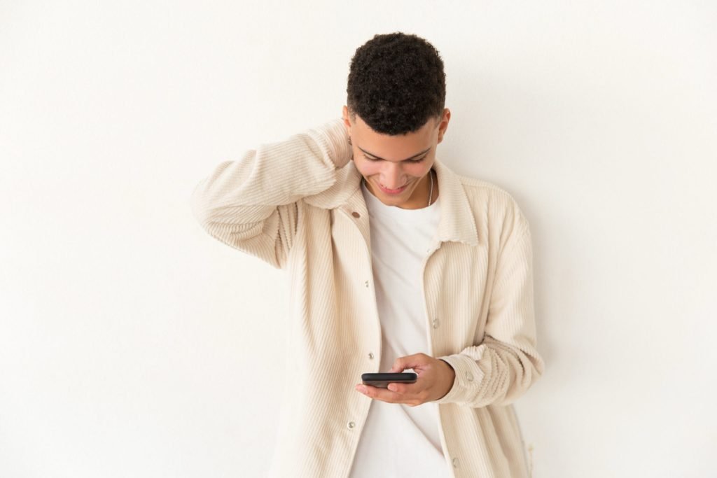 Cheerful young man using mobile phone