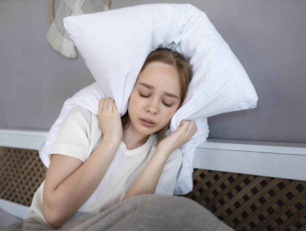 Medium shot woman covering her ears with pillow