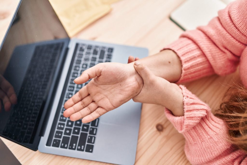 Young beautiful hispanic woman ecommerce business worker suffering wrist pain office