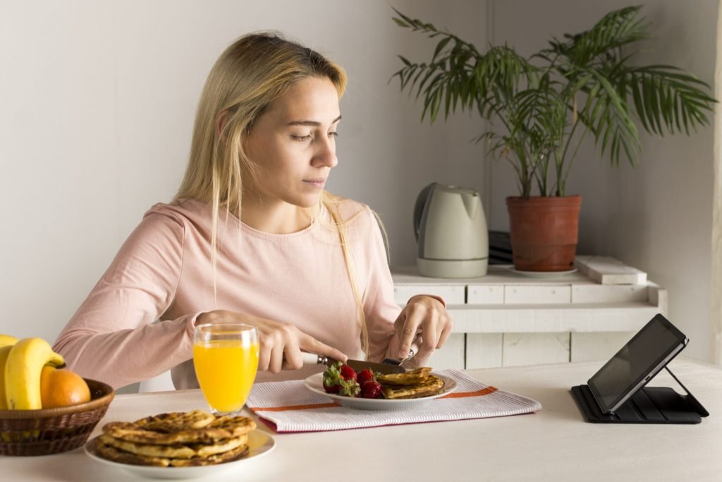 Girl having waffles watching tablet
