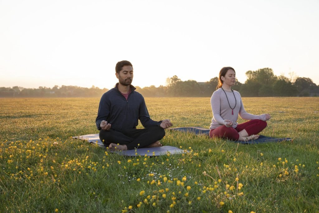 Man woman doing yoga together outdoors