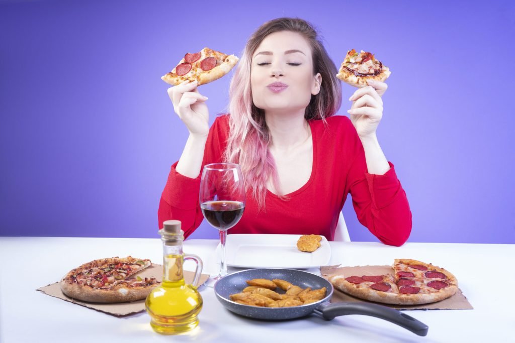 Nice woman comparing taste two different slices pizza