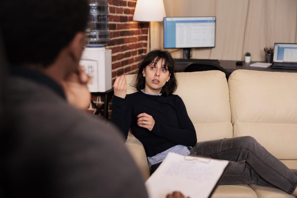 Unhappy woman laying sofa psychotherapy session with therapist talking about stress problems receiving support help from p...