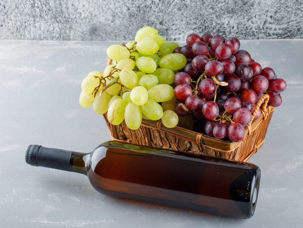 Grapes basket with drink bottle high angle view plaster grungy